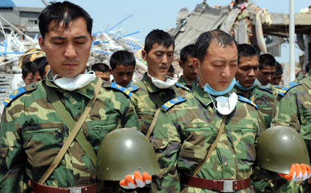 Relief troops mourn during a silent tribute in Mianzhu, quake-hit southwest China's Sichuan Province, May 19, 2008. Millions of people in China and overseas observed three minutes silence at 2:28 p.m. Monday to mourn thousands of people killed in an earthquake which hit the nation's southwestern regions a week ago. Across the country, air raid sirens, cars, trains and ship horns wailed in grief as the people fell silent. (Xinhua/Yang Ying)