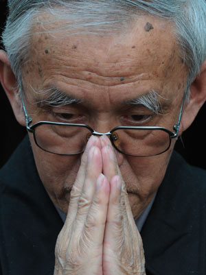 A senior citizen mourns in a silent tribute to the people killed in the earthquake during a suspension in Guiyang, southwest China's Guizhou Province, May 19, 2008.