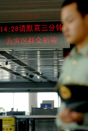 A soldier mourns in a silent tribute to the people killed in the earthquake during a suspension at the Xiaoshan airport in Hangzhou, capital of east China's Zhejiang Province, May 19, 2008.