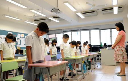 Students and a teacher mourn during a silent tribute at a middle school classroom in Hong Kong, south China, May 19, 2008.