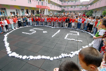 About 1,000 children and teachers attend a silent tribute for victims of the May 12 quake hitting southwest and northwest China, at Heqin Kindergarten in Shangyu City, east China's Zhejiang Province, May 19, 2008.