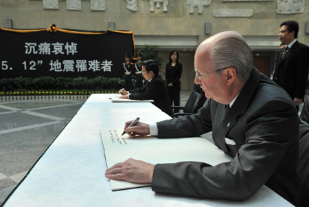 A United States diplomat signs on the book to express condolence for the victims of the May 12 earthquake hitting southwest and northwest China, at China's Foreign Ministry in Beijing, capital of China, May 19, 2008. (Xinhua/Luo Xiaoguang)