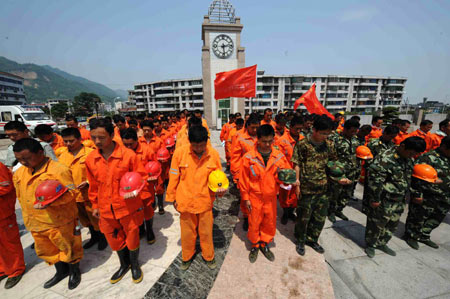Rescuers mourn during a silent tribute at a square in Hanwang town of Mianzhu in the quake-hit Sichuan Province, southwest China, May 19, 2008. (Xinhua Photo/Wang Jianhua)