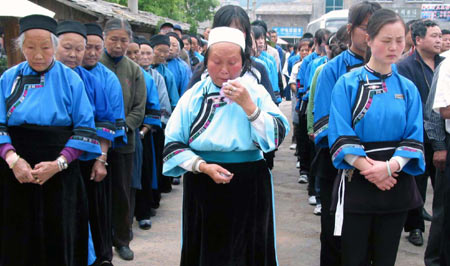 Tourists and local villagers mourn during a silent tribute in Tianlong town of Pingba, southwest China's Guizhou Province, May 19, 2008. China began on May 19 a three-day mourning for the victims of the 8.0-magnitude quake hitting southwest and northwest China on May 12.