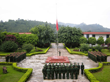 Soldiers of frontier defence watch as China's national flag flies at half-mast in the Dai Ethnic Autonomous Prefecture of Xishuangbanna, southwest China's Yunnan Province, May 19, 2008. China on Monday begins a three-day national mourning for the tens of thousands of people killed in a powerful earthquake which struck the country's southwestern regions on May 12.