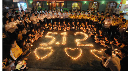 Citizens mourn around candles during a memorial ceremony in Nanning, capital of southwest China's Guangxi Zhuang Autonomous Region, May 19, 2008. China began on Monday a three-day mourning for the victims of the 8.0-magnitude quake on Richter scale hitting southwest and northwest China on May 12.