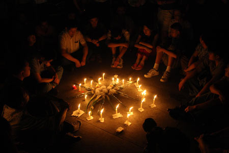 People mourn around candles at a memorial ceremony in Chengdu, capital of southwest China's Sichuan Province, May 19, 2008. China began on Monday a three-day mourning for the victims of the 8.0-magnitude quake on Richter scale hitting southwest and northwest China on May 12.