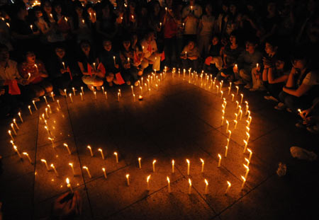 Citizens mourn around candles during a memorial ceremony in Guilin, southwest China's Guangxi Zhuang Autonomous Region, May 19, 2008. China began on Monday a three-day mourning for the victims of the 8.0-magnitude quake on Richter scale hitting southwest and northwest China on May 12.