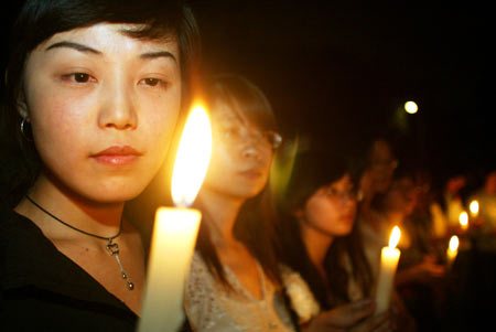 Students holding candles mourn at a memorial ceremony in Chengdu, capital of southwest China's Sichuan Province, May 19, 2008. China began on Monday a three-day mourning for the victims of the 8.0-magnitude quake on Richter scale hitting southwest and northwest China on May 12.
