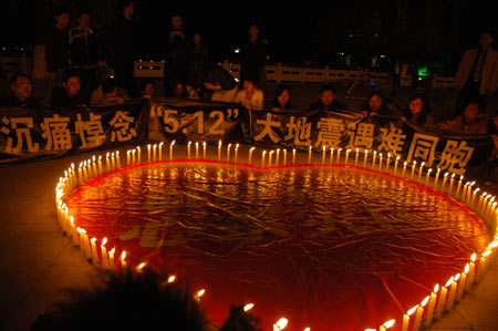 People mourn beside candles at a memorial ceremony at the Potala Palace Square in Lhasa, capital of southwest China's Tibet Autonomous Region, May 19, 2008. China began on Monday a three-day mourning for the victims of the 8.0-magnitude quake on Richter scale hitting southwest and northwest China on May 12.