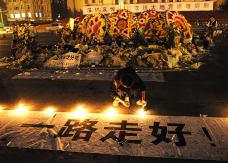 A boy lights candles at a memorial ceremony in Chengdu, capital of southwest China's Sichuan Province, May 19, 2008. China began on Monday a three-day mourning for the victims of the 8.0-magnitude quake on Richter scale hitting southwest and northwest China on May 12.