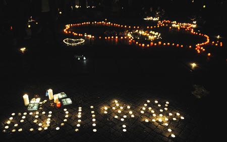 People lay candles forming a map of China and the characters of "Wenchuan, China" at the square in front of the assembly building during a candlelight memorial activity in Berlin, capital of Germany, May 19, 2008. People held a candlelight memorial here Monday to mourn thousands of victims killed in the 8.0-magnitude earthquake on Richter scale which hit southwest and northwest China