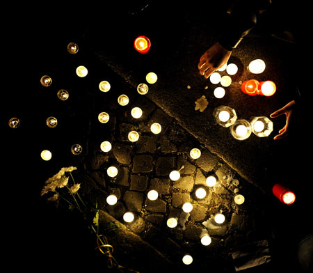 People lay candles forming the characters of "Wenchuan" at the square in front of the assembly building during a candlelight memorial activity in Berlin, capital of Germany, May 19, 2008. People held a candlelight memorial here Monday to mourn thousands of victims killed in the 8.0-magnitude earthquake on Richter scale which hit southwest and northwest China