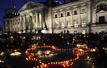 People lay candles at the square in front of the assembly building during a candlelight memorial activity in Berlin, capital of Germany, May 19, 2008. People held a candlelight memorial here Monday to mourn thousands of victims killed in the 8.0-magnitude earthquake on Richter scale which hit southwest and northwest China's regions.