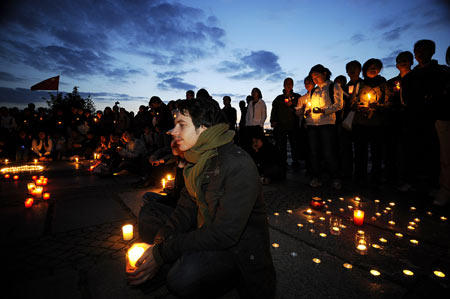 People lay candles on the square in front of the assembly building during a candlelight memorial activity in Berlin, capital of Germany, May 19, 2008. People held a candlelight memorial here Monday to mourn thousands of victims killed in the 8.0-magnitude earthquake on Richter scale which hit southwest and northwest China's regions.