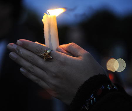 A woman holds a candle praying for the people in the quake-hit southwest and northwest China's regions during a candlelight memorial activity on the square in front of the assembly building in Berlin, capital of Germany, May 19, 2008. People held a candlelight memorial here Monday to mourn thousands of victims killed in the 8.0-magnitude earthquake on Richter scale which hit southwest and northwest China's regions.