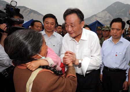 Wu Bangguo, chairman of the Standing Committee of the National People's Congress and a member of the Standing Committee of the Political Bureau of the Communist Party of China (CPC) Central Committee, shakes hands with a victim as he visits the Yingxiu Town of Wenchuan County in southwest China's Sichuan Province May 27, 2008. Wu arrived in Wenchuan County and Dujiangyan city on Tuesday to direct disaster relief work in the quake-ravaged areas.