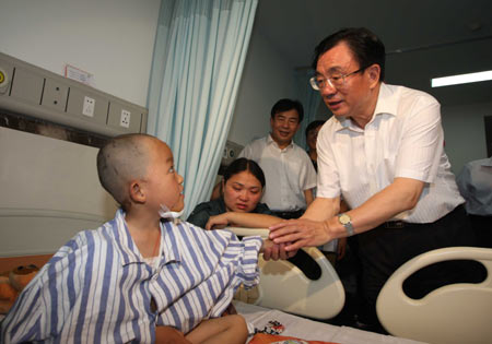 He Guoqiang (R), a member of the Standing Committee of the Political Bureau of the Communist Party of China (CPC) and the secretary of the CPC Central Commission for Discipline Inspection, visits Li Rui, a 4-year-old boy injured during Sichuan's 8-magnitude quake last week, at a hospital in southwest China’s Chongqing Municipality on May 20, 2008.