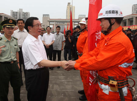 He Guoqiang (L), a member of the Standing Committee of the Political Bureau of the Communist Party of China (CPC) and the secretary of the CPC Central Commission for Discipline Inspection, shakes hands with a man of police rescue team before their departure in southwest China’s Chongqing Municipality on May 20, 2008.
