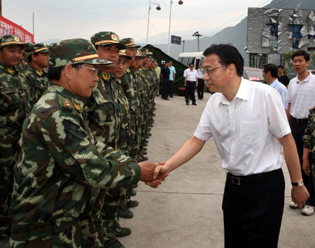 Li Keqiang (R Front), Chinese vice premier and member of the Standing Committee of the Political Bureau of the Communist Party of China (CPC) Central Committee, shaks hands with quake-relief soldiers near a tunnel at Xuankou Town of Wenchuan County, the epicenter of the May 12 magnitude 8 quake, in Chengdu, capital of southwest China's Sichuan Province, on May 20, 2008.