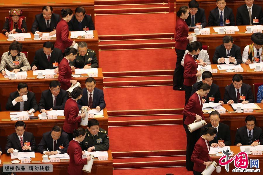 2015年3月5日，人民大会堂服务员为主席团成员茶杯续水，动作整齐划一。 中国网记者 董宁/摄影