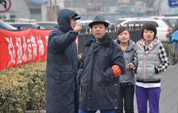 首都治安志愿者用自己的方式为两会顺利召开保驾护航，图为首都治安志愿者为路人指路。人民网记者 刘倩摄影