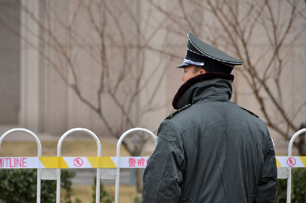 代表团驻地外的一名保安在小雪中坚守岗位。人民网记者 刘倩摄影