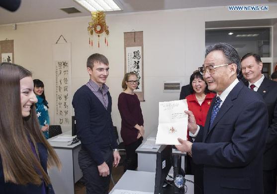 Wu Bangguo (R front), chairman of the Standing Committee of the National People's Congress of China, receives a Chinese greeting card from a Russian student during his visit to the Confucius Institute at Russian Far Eastern Federal University in Vladivostok, Russia, Jan. 29, 2013.(Xinhua/Wang Ye) 