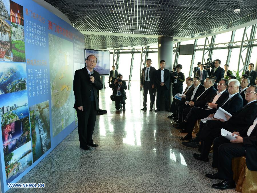 Wu Bangguo (3rd R, front), chairman of the National People's Congress (NPC) Standing Committee, listens to the introduction on the city planning in Macao Tower in Macao, south China, Feb. 21, 2013.