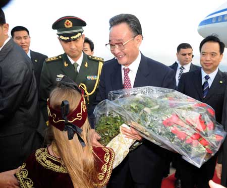 Wu Bangguo (R Front), chairman of the Standing Committee of China's National People's Congress, is presented with flowers upon his arrival at an airport in Algiers, capital of Algeria, on Nov. 3, 2008.