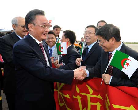 Wu Bangguo (L, front), chairman of the Standing Committee of China's National People's Congress, shakes hands with people welcoming his arrival at an airport in Algiers, capital of Algeria, on Nov. 3, 2008.