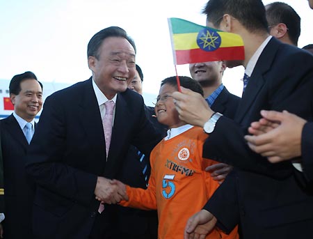 Wu Bangguo (L Front), chairman of the Standing Committee of China's National People's Congress, the country's top legislature, shakes hands with a boy greeting him at the airport in Addis Ababa, capital of Ethiopia, Nov. 8, 2008. Wu Bangguo arrived in Addis Ababa for an official goodwill visit to Ethiopia on Nov. 8.