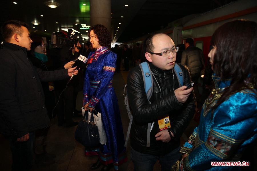 Jiang Lan (3rd R) and Yi Yongchun (1st R), deputies to the 12th National People's Congress (NPC) from north China's Inner Mongolia Autonomous Region, are interviewed upon their arrival in Beijing, capital of China, March 2, 2014. The second session of the 12th NPC, the national legislature, is scheduled to open in Beijing on March 5. (Xinhua/Jin Liwang) 