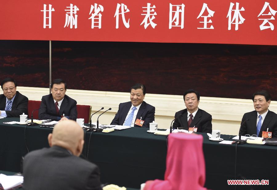 Liu Yunshan (C rear), a member of the Standing Committee of the Political Bureau of the Communist Party of China (CPC) Central Committee and secretary of the Secretariat of the CPC Central Committee, joins a discussion with deputies to the 12th National People's Congress (NPC) from northwest China's Gansu Province during the second session of the 12th NPC, in Beijing, capital of China, March 11, 2014. (Xinhua/Li Xueren)