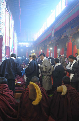 Buddhism followers give alms during a Buddhist ceremony at the Sera Monastery in the suburb of Lhasa, capital of southwest China's Tibet Autonomous Region, March 4, 2009.