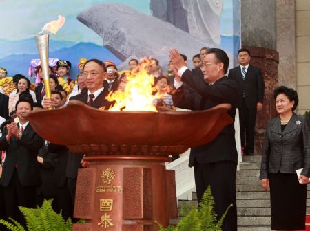 Wu Bangguo (R, front), chairman of the Standing Committee of China's National People's Congress, watches the torch during the starting ceremony of the 11th National Games torch relay at the east gate of the Great Hall of the People in Beijing, capital of China, on Aug. 16, 2009. The 11th edition of the National Games, which are held every four years, will take place in Shandong Province from Oct. 16 to 28.(Xinhua/Pang Xinglei) 