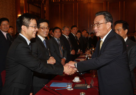 Wu Bangguo (R Front), chairman of the Standing Committee of the National People's Congress, China's top legislature, shakes hands with a representative of Chinese entrepreneurs working in Italy at Milan on May 19, 2009. (Xinhua/Liu Weibing)