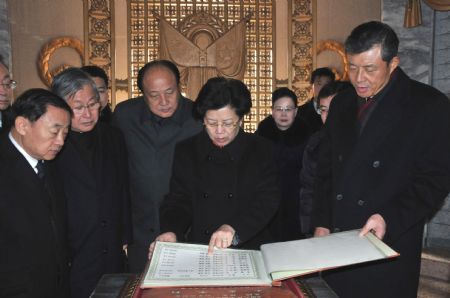 Chen Zhili (C), vice chairwoman of the Standing Committee of China's National People's Congress (NPC), reads a name list of the Chinese People's Volunteers who lost their lives during the Korean War, after she lays a wreath before the Korea-China Friendship Tower in Pyongyang, capital of the Democratic People's Republic of Korea (DPRK), Dec. 1, 2009.(Xinhua/Yao Ximeng)