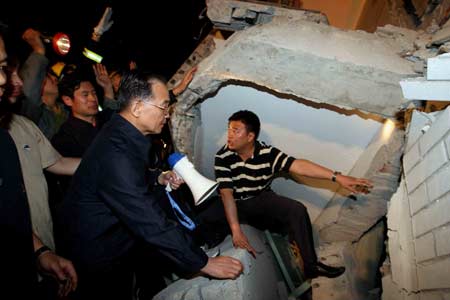 Chinese Pemier Wen Jiabao (2nd R) speaks to buried people at a ruined hospital in Dujiangyan city of southwest China's Sichuan Province May 12, 2008. Premier Wen flew into southwest China's Sichuan Province on Monday. 
