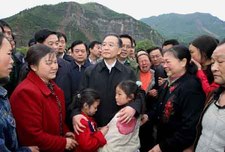Chinese Premier Wen Jiabao (C) consoles locals as he pays a visit to Beichuan County, which neighbors the epicenter of the massive quake in southwest China's Sichuan Province, May 14, 2008. Wen Jiabao arrived on Wednesday at Beichuan County, one of the regions worst hit by Monday's massive earthquake, to oversee the rescue work. 