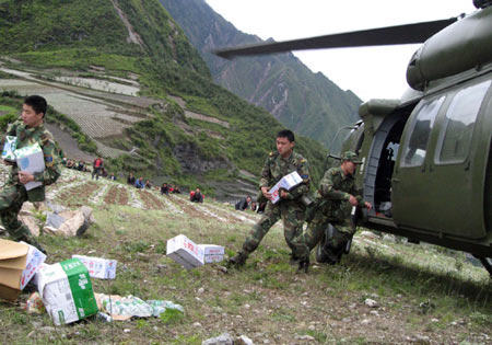 Soldiers from the People's Liberation Army carry relief materials after their arrival in the quake-stricken Wenchuan County in southwest China's Sichuan Province, May 14, 2008. A strong quake measuring 7.8 on the Richter scale struck Wenchuan at 2:28 p.m. on Monday. 