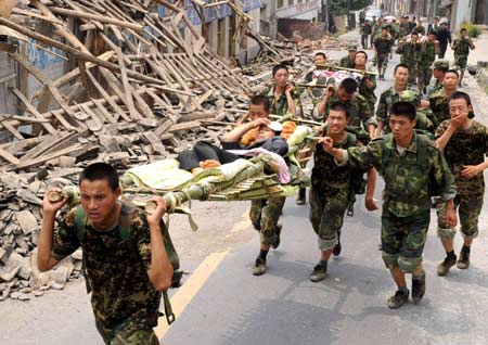 Chinese People's Liberation Army (PLA) soldiers transfer the injured victims to the safe areas in the quake-hit Qingchuan County, southwest China's Sichuan Province, May 17, 2008. 