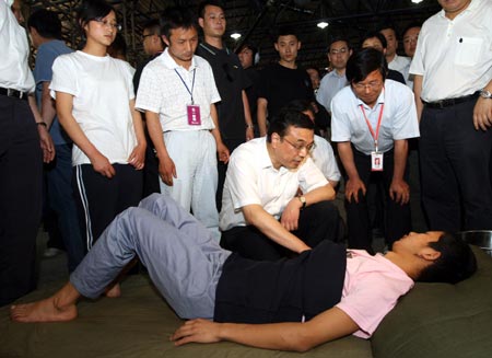 Chinese Vice Premier Li Keqiang, also member of the Standing Committee of the Political Bureau of the Communist Party of China (CPC) Central Committee, consoles a victim in Pingtong Township of Pingwu County, Mianyang, southwest China’s Sichuan Province May 18, 2008. Li Keqiang, who is also vice head of the General Headquarters for Earthquake Relief under the State Council led by Chinese Premier Wen Jiabao, arrived in the quake-hit Mianyang city on Sunday to oversee disaster relief work.