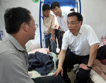 Chinese Vice Premier Li Keqiang, also member of the Standing Committee of the Political Bureau of the Communist Party of China (CPC) Central Committee, consoles a victim in Pingtong Township of Pingwu County, Mianyang, southwest China’s Sichuan Province May 18, 2008. Li Keqiang, who is also vice head of the General Headquarters for Earthquake Relief under the State Council led by Chinese Premier Wen Jiabao, arrived in the quake-hit Mianyang city on Sunday to oversee disaster relief work.