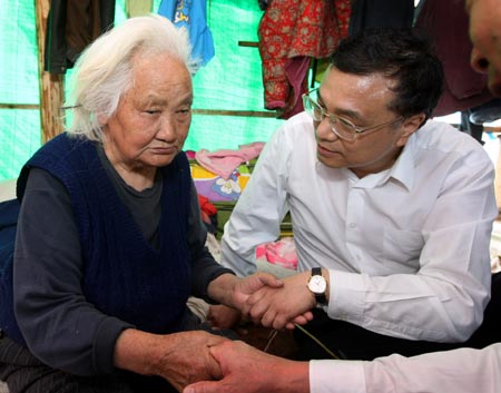 Chinese Vice Premier Li Keqiang (R), also member of the Standing Committee of the Political Bureau of the Communist Party of China (CPC) Central Committee, comforts a blind old lady survived the quake during his visit in Anxian county of hard-hit southwest Sichuan Province to direct quake relief on May 19, 2008. 