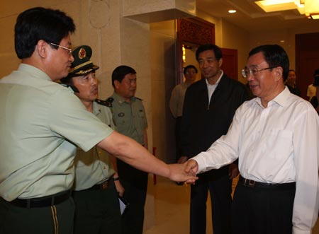 He Guoqiang (R), secretary of the Central Commission for Discipline Inspection of the Communist Party of China (CPC), shakes hands with officers of the rescue teams during his visit on May 19, 2008 to southwest China's Chongqing Municipality that neighbors Sichuan Province, which was rocked by an 8-magnitude earthquake on May 12.