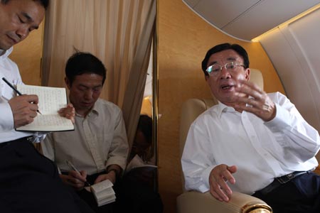 He Guoqiang (R), secretary of the Central Commission for Discipline Inspection of the Communist Party of China (CPC), talks with officials on the plane as he flies on May 19, 2008 to southwest China's Chongqing Municipality that neighbors Sichuan Province, which was rocked by an 8-magnitude earthquake on May 12.