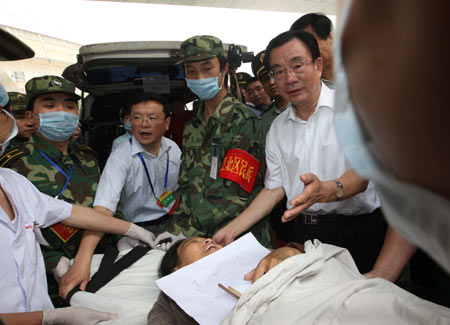  He Guoqiang (1st R), a member of the Standing Committee of the Political Bureau of the Communist Party of China (CPC) and the secretary of the CPC Central Commission for Discipline Inspection, visits Chen Zhongfeng, a 54-year-old local resident injured during Sichuan's 8-magnitude quake last week, at North Railway Station in southwest China’s Chongqing Municipality on May 20, 2008. 