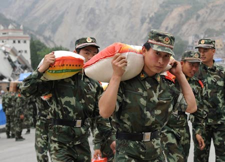 The armed police carry relief materials in Yingxiu Town, Wenchuan County, southwest China's Sichuan Province, May 28, 2008.