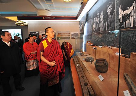 The 11th Panchen Lama Erdeni Gyaincain Norbu (front) looks at the exhibits during an exhibition titled 